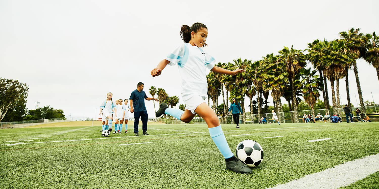 Youth soccer player practicing a kick on the field, showing the movement, strength, and coordination young athletes need to play well.
