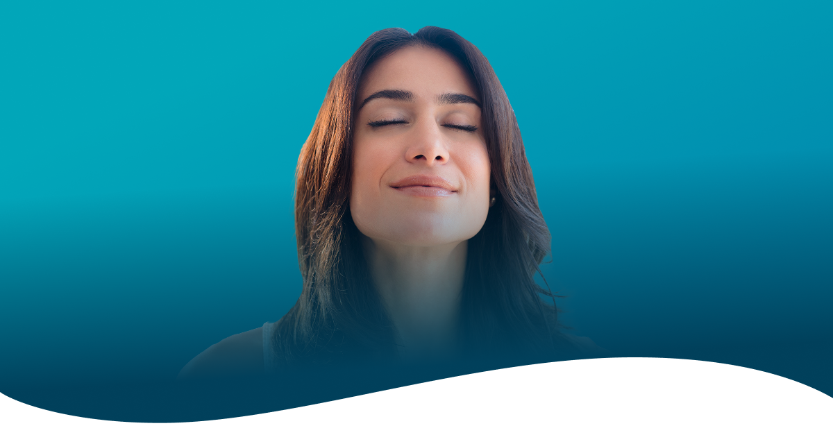 Photo of a woman smiling because she just experienced pain relief after her first chiropractic adjustment.